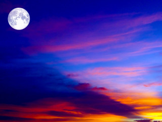 Fototapeta premium full moon on colorful sky in orange red and dark gray cloud