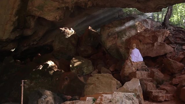 Amazing Buddhism with the ray of light in the cave, Krabi Province, Thailand.