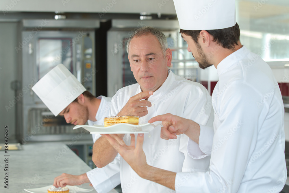 Wall mural apprentices chefs at work with experienced master