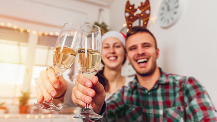 Merry Christmas and Happy New Year! Couple drinking champagne at home for Christmas
