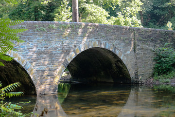 Fototapeta na wymiar An old Bridge over a Forest Stream 