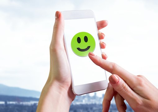 Hand Touching Smiley Face On Phone