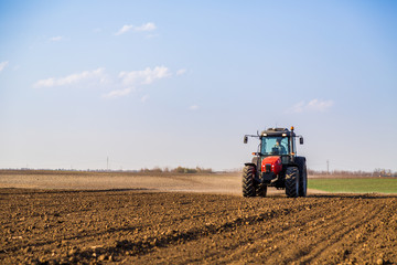 Obraz premium Farmer fertilizing arable land with nitrogen, phosphorus, potassium fertilizer