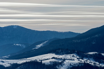 Striped sky over the mountains in winter.