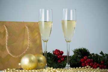 Champagne flute and christmas decoration against white