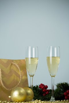 Champagne flute and christmas decoration against white