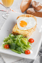 Toasts with fried eggs and cheese served with lettuce and tomato. Breakfast conception with fresh orange juice