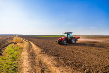 Obraz premium Farmer fertilizing arable land with nitrogen, phosphorus, potassium fertilizer