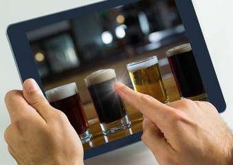 Hand touching tablet with beers selection in bar
