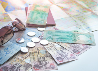 Arab dirhams and passport on the background of the card and sunglasses. The concept of travel.
