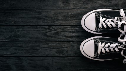Sneakers, sports shoes on a wooden background. Top view. Free space for text.