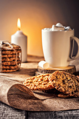 Winter autumn still life  homemade recipe honey ginger oatmeal cookie and bagel, cocoa cup coffee with marshmallow on wooden table kitchen