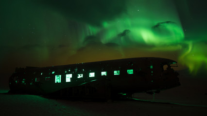 Airplane wreck at night with Aurora borealis