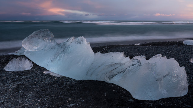 Glacial fragment of ice on black beach at sunset, Jokulsarlon Iceland