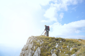 Hikers with backpacks relaxing on top of a mountain and enjoying the view of valley