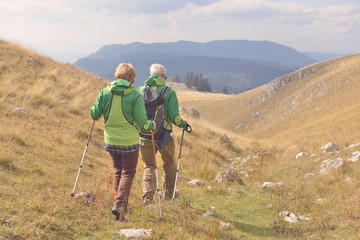Fototapeta na wymiar Senior tourist couple hiking at the beautiful mountains