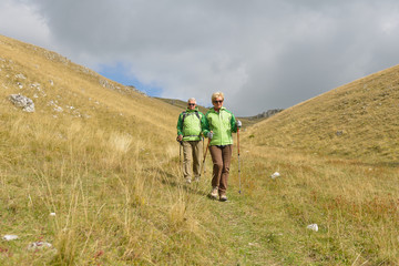 Fototapeta na wymiar Senior tourist couple hiking at the beautiful mountains