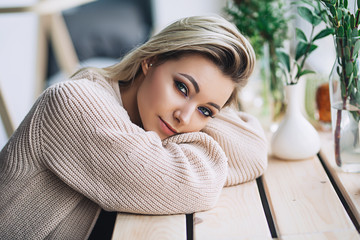 Beautiful white stylish woman in cozy scandinavian interrior sits at home near the big window, portrait of the beautiful girl, fashion portraits, woman with style © thekotlyar