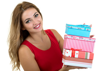 Portrait of a smiling pretty girl holding stack of gift boxes isolated over white background