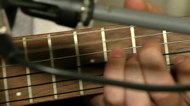 Close-up music playing on a wooden guitar. Guitarist to pluck the strings. A performance by the musician on a stringed instrument. 