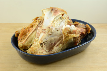 Turkey bones left over from Thanksgiving or Christmas meal in blue bowl on table