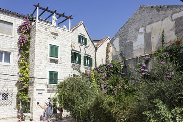 Fototapeta na wymiar Ancient building in Split in summer season, with many flower and plants