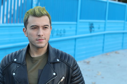 Head shot of handsome green haired young man outdoors