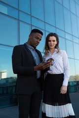 Male and female executive using glass digital tablet