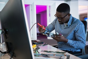 Fototapeta na wymiar Computer african american engineer repairing motherboard at desk