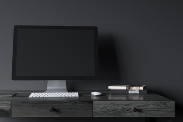 Black computer screen on a black wooden desk