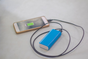 Charge the phone power Bank white table background.