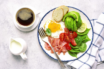 Fototapeta na wymiar Fried egg,salted salmon,tomato,spinach and avocado - concept of healthy breakfast.Top view.