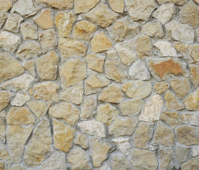 Old yellow stone pavement texture. Ancient natural cobblestone road as background. Abstract background of old cobblestone pavement.