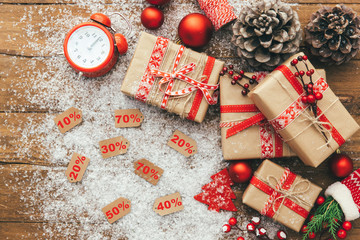 Obraz na płótnie Canvas Winter sale concept. Christmas discount with gift boxes over wooden background. Sales Discount Tag with different percent