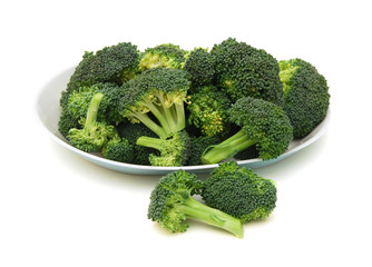 branches of cabbage of a broccoli in plate on a white background