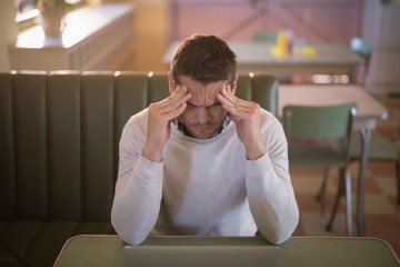 Depressed man sitting in restaurant