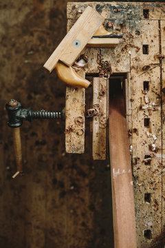 used workbench with a bench vice, wood plane and wood chips from
