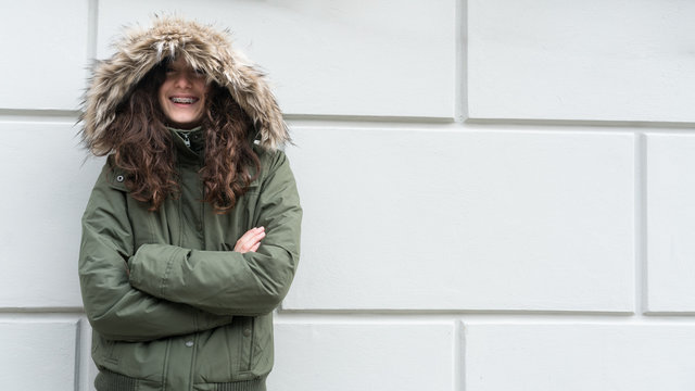 Teenager looking  and laughing at camera in winter coat