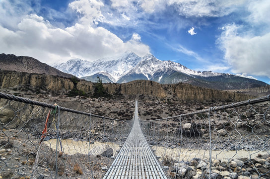 Suspencion bridge across the mountain river in Himalayas