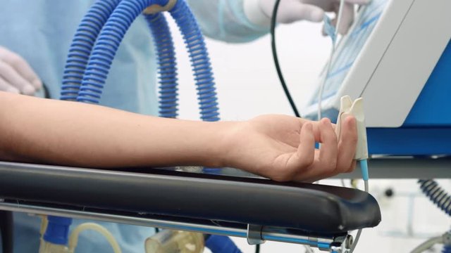 Anesthesiologist works with patient in surgery room during operation