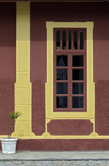 Windows with yellow frame on red wall, in old train station