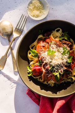 puttanesca pasta garnished with fresh parmesan cheese