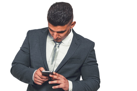 A handsome businessman in an elegant suit with a mobile phone in his hand.