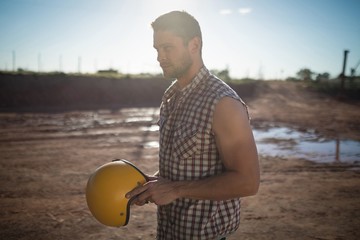 Man holding a helmet on a sunny day