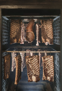 Dried aged bacon and lomo hanging in a smoking chamber