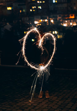 Woman drawing heart shape with sparkler