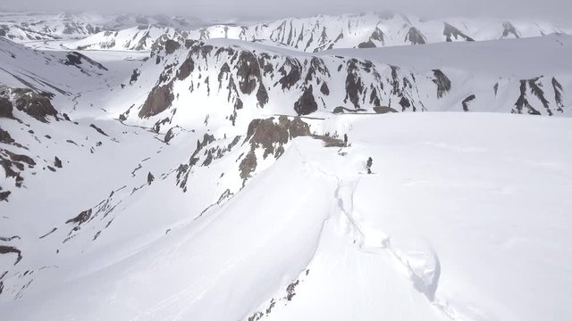 Skiers in vast mountain landscape, Iceland aerial