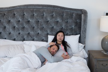 Man and pregnant woman relaxing in bedroom