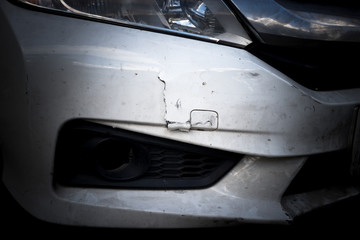 Broken front bumper of white car