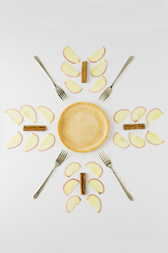 Pie crust with apple slices and cinnamon sticks